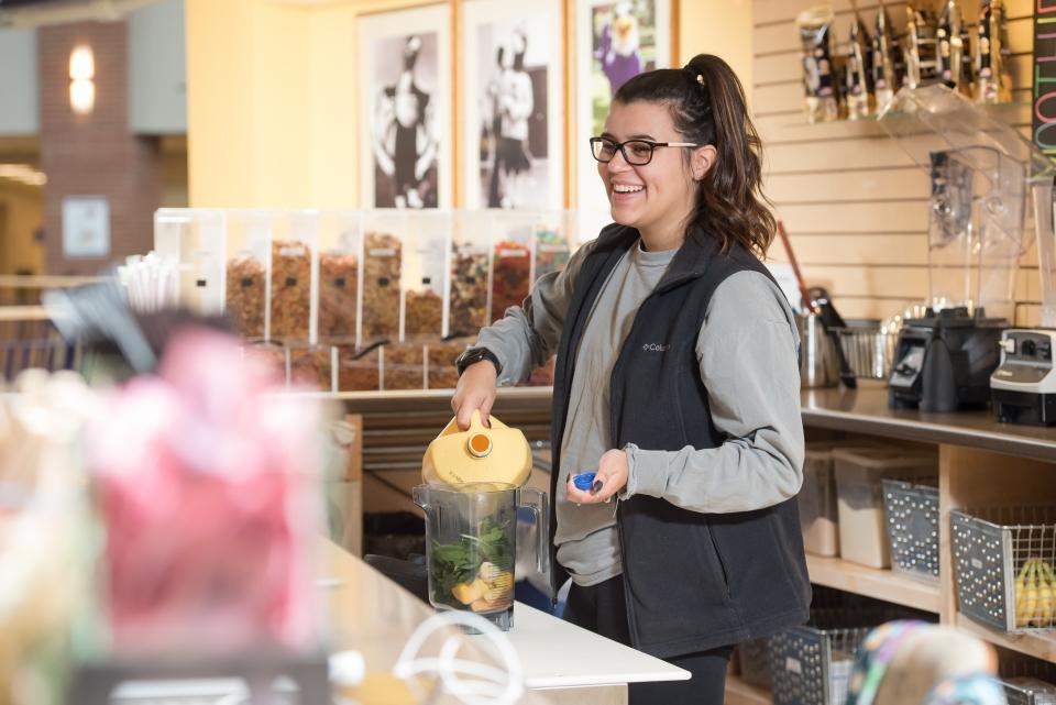 Server at Tuffy's Smoothie Bar prepares a smoothie for a customer