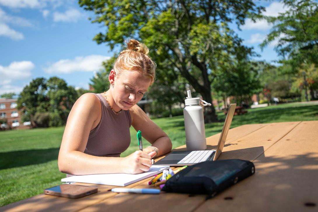 student studying at picnic table