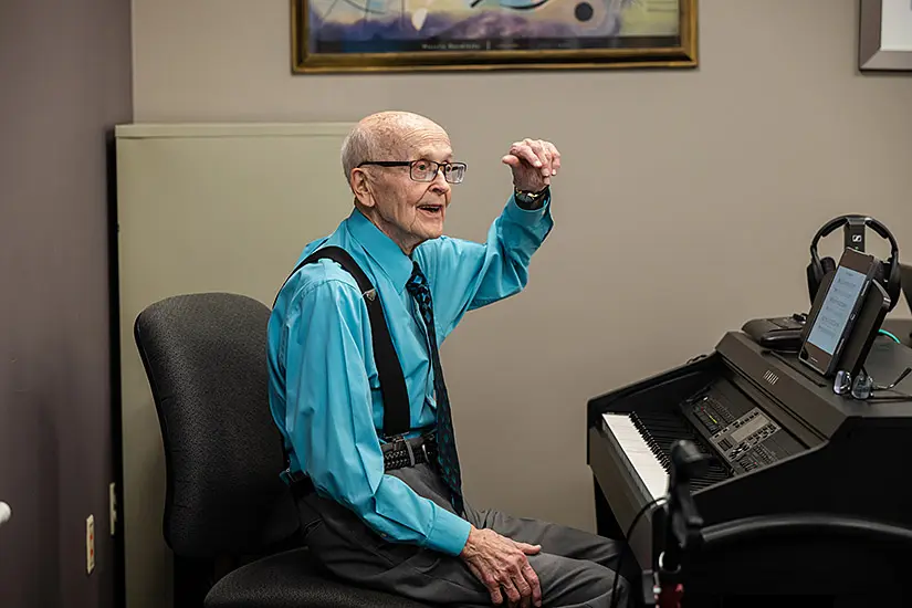 Ron Sprunger plays piano at the dedication of the new piano lab