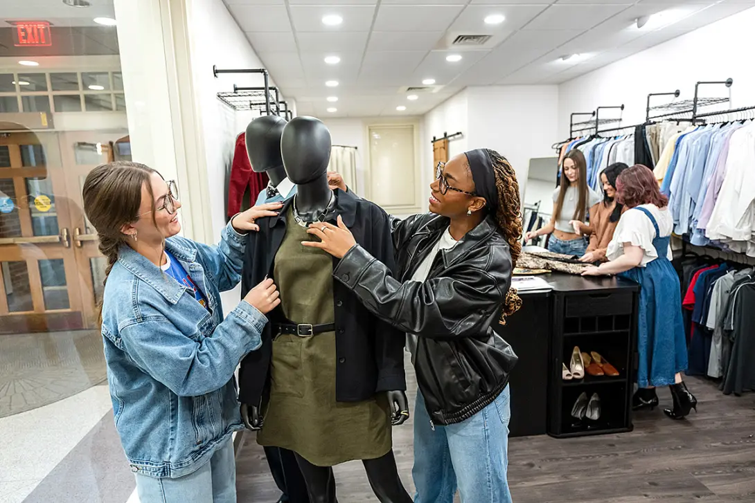 fashion merchandising students dressing a manikin 
