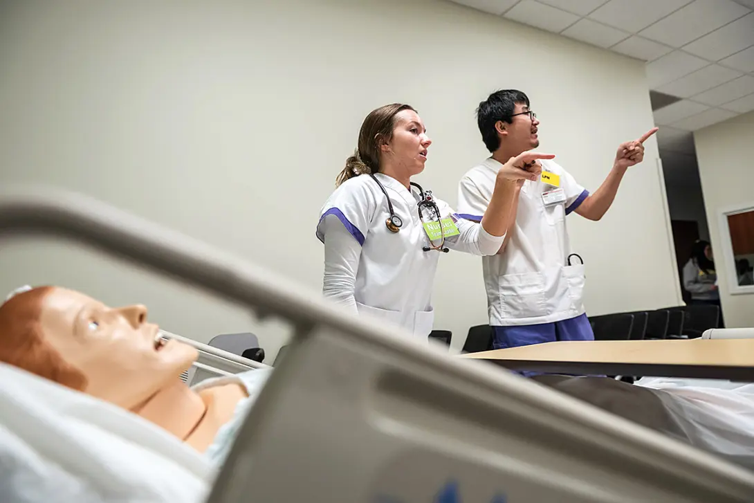 nursing students along with manikin at the Dwight Schar College of Nursing and Health Sciences