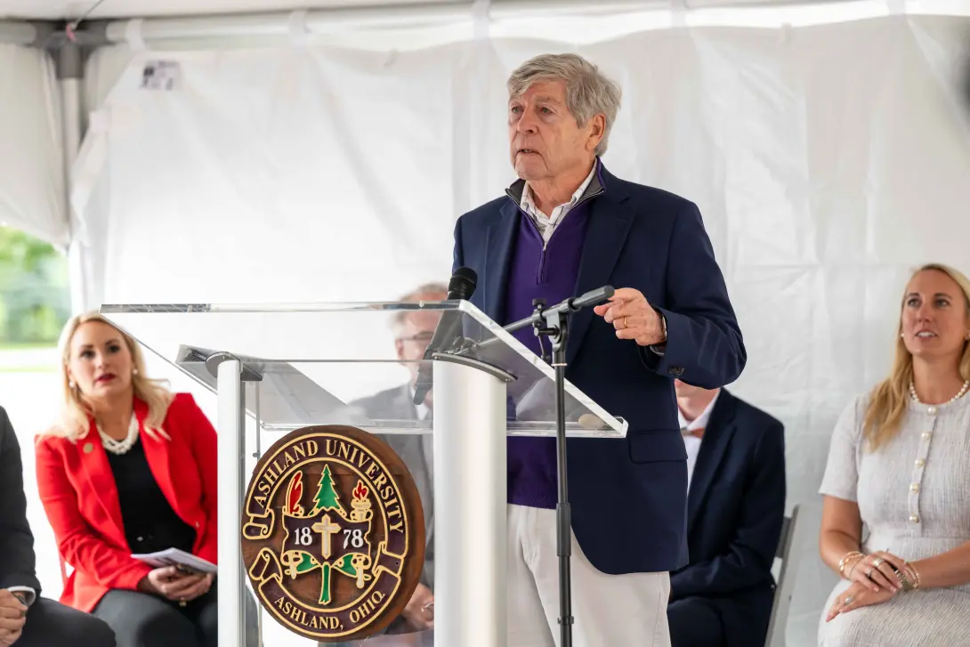 Dwight Schar speaks at the podium during the Schar Plaza dedication