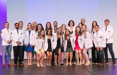 AU’s physician assistant students on stage in their white coats